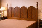 Solid wood arched panel headboard detail with premium walnut polish