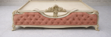 Classic handcrafted wooden upholstered bed with pink velvet tufted headboard and luxury royal bedroom style.