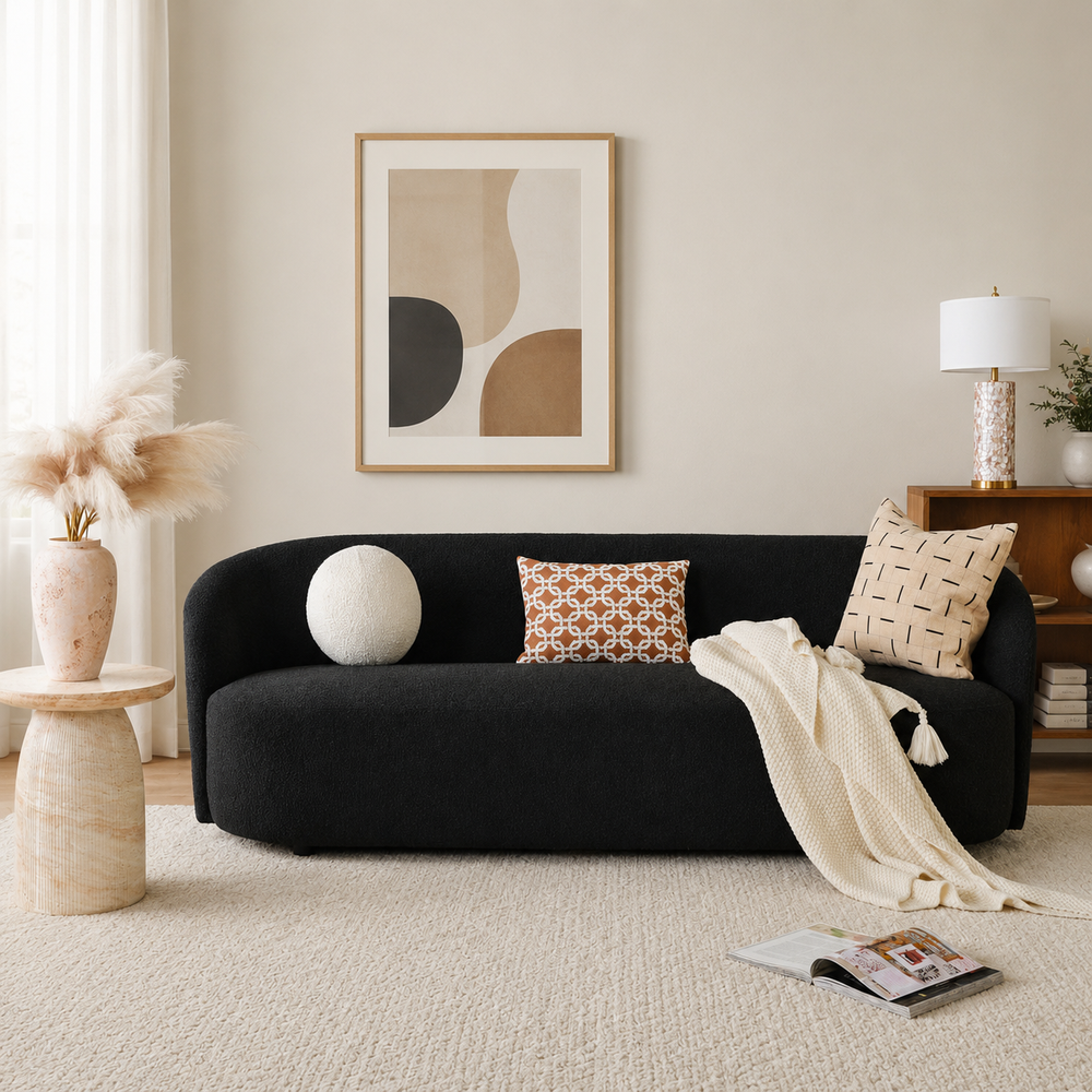 Curved black bouclé sofa with solid teak wood frame in modern living room