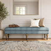 Teak wood upholstered bench with blue fabric seat and turned legs