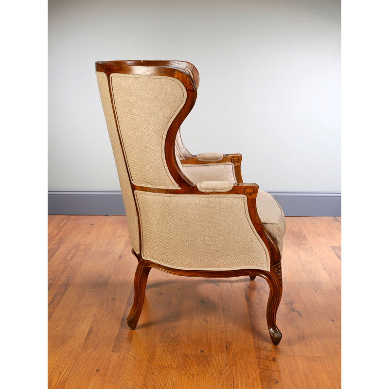 beige wingback chair with carved teak wood frame
