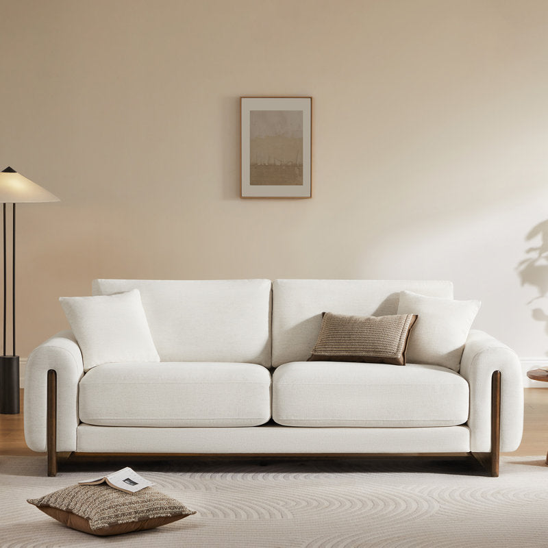 Contemporary teak wood couch with plush cushions and curved armrests