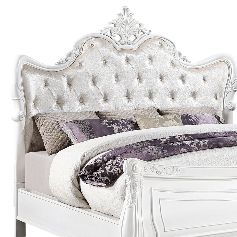White carved wooden king size bed with tufted headboard