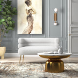 Curved white bouclé sofa with gold legs and teak wood frame