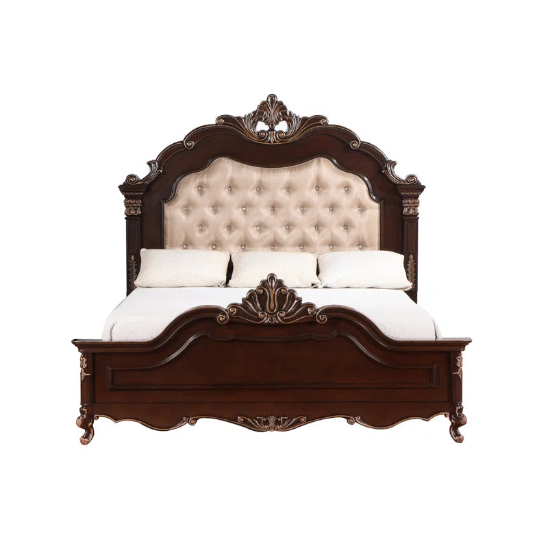 Ornate wooden bed with soft fabric headboard